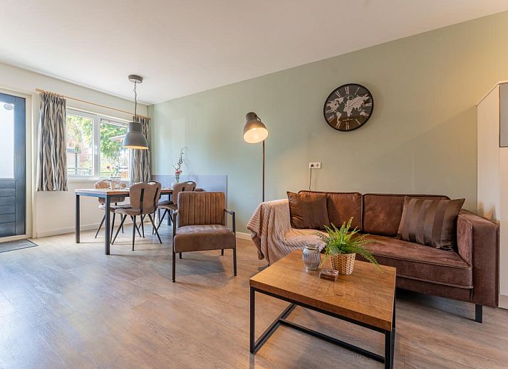 Geraeumige Terrasse des Ferienhauses Pimpelmees in Hulshorst, Veluwe mit Sitzgelegenheit und Sonnenschirm.