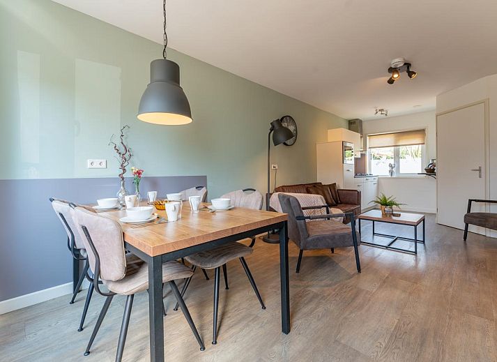 Geraeumige Terrasse des Ferienhauses Pimpelmees in Hulshorst, Veluwe mit Sitzgelegenheit und Sonnenschirm.