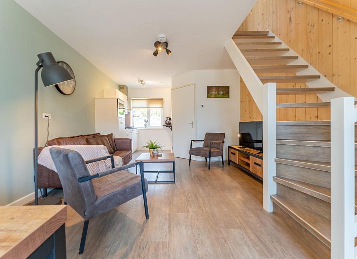 Geraeumige Terrasse des Ferienhauses Pimpelmees in Hulshorst, Veluwe mit Sitzgelegenheit und Sonnenschirm.