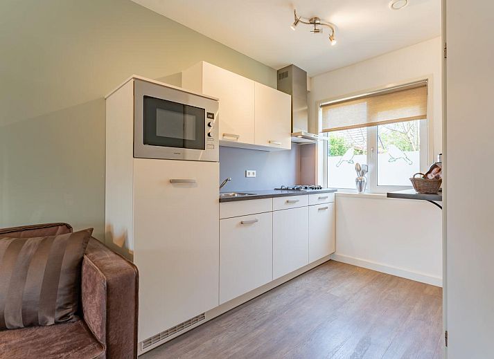 Essecke des Ferienhauses Pimpelmees in Hulshorst, Veluwe mit stimmungsvoller Beleuchtung und Aussicht.