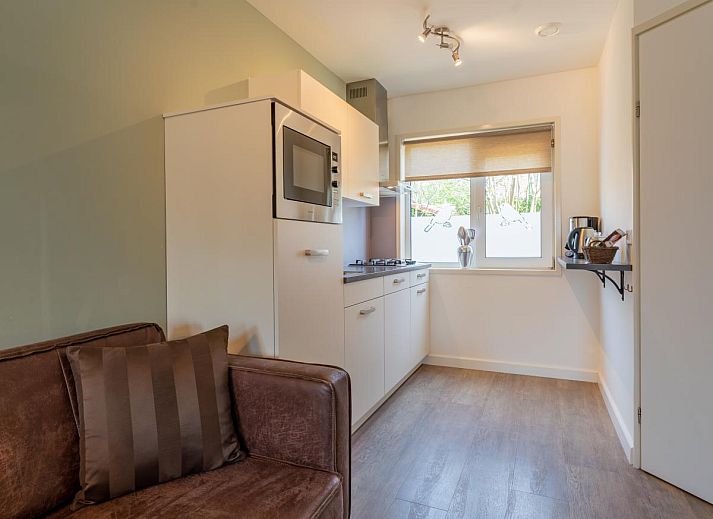 Essecke des Ferienhauses Pimpelmees in Hulshorst, Veluwe mit stimmungsvoller Beleuchtung und Aussicht.