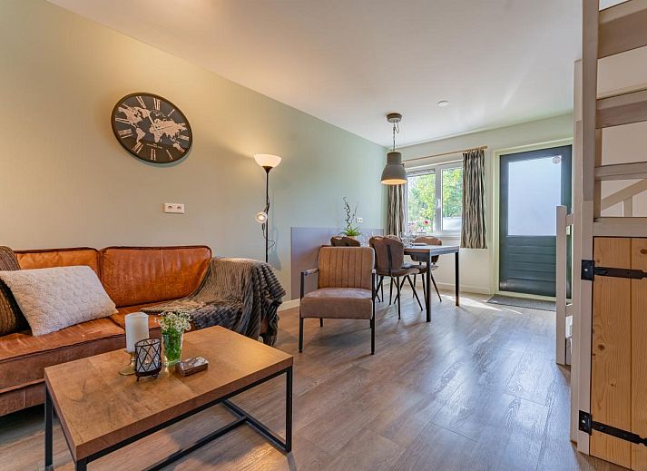 Cozy living room in vacation home Koolmees, Hulshorst, Veluwe with comfortable sofa and wooden interior.