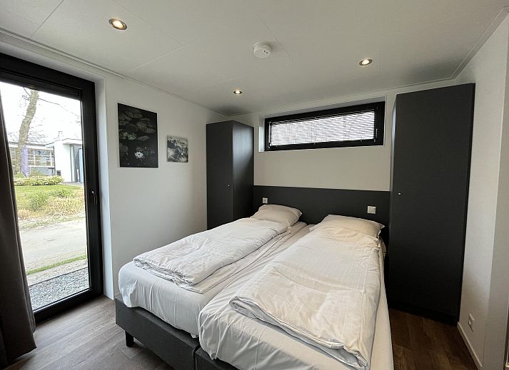 Gezellige woonkamer met uitzicht op het terras en het water bij de Vrijstaande woning in Hulshorst, Veluwe, Gelderland.