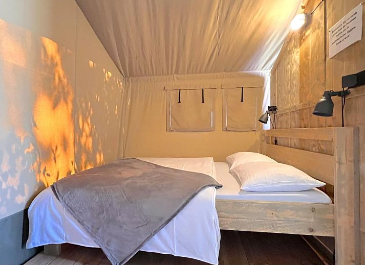 Kinder spielen vor dem Zelthaus De Bij in Hulshorst, Veluwe, mit bunter Beleuchtung und Terrasse.