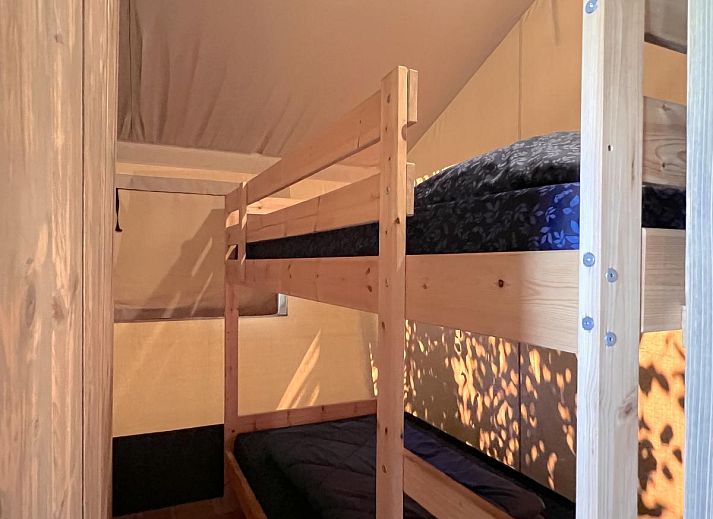 Kinder spielen vor dem Zelthaus De Bij in Hulshorst, Veluwe, mit bunter Beleuchtung und Terrasse.