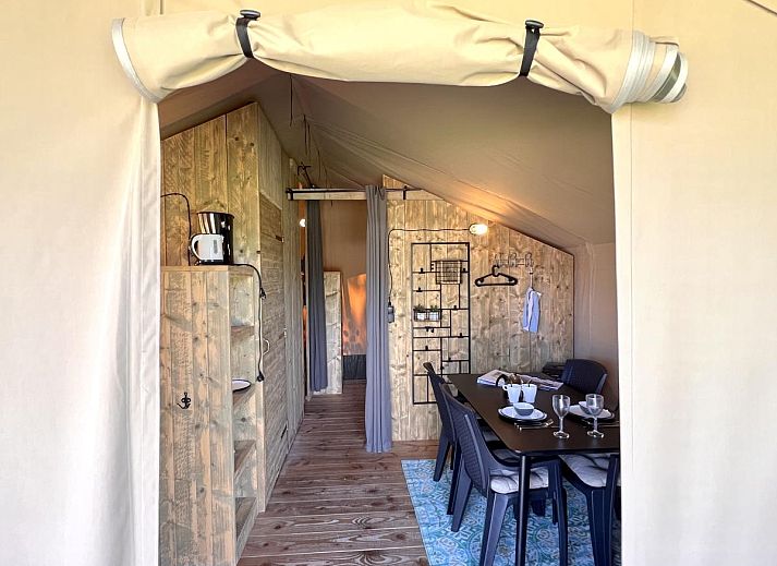 Geraeumige Veranda des Zelthauses De Bij in Hulshorst, Veluwe, mit bequemen Sitzgelegenheiten und Aussicht.