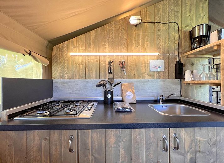 Geraeumige Veranda des Zelthauses De Bij in Hulshorst, Veluwe, mit bequemen Sitzgelegenheiten und Aussicht.