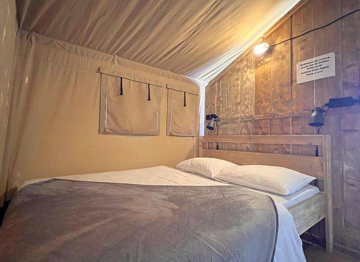 Geraeumige Veranda des Zelthauses De Bij in Hulshorst, Veluwe, mit bequemen Sitzgelegenheiten und Aussicht.