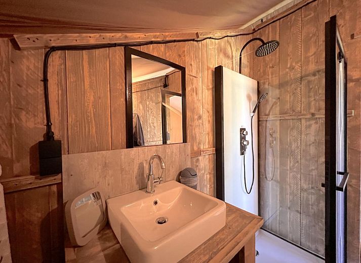 Essbereich in der Zelthuette De Bij in Hulshorst, Veluwe, mit moderner Einrichtung und Holzdetails.