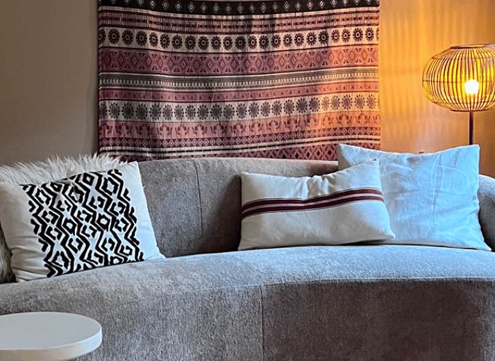 Gezellige woonkamer van Vakantiehuisje in Otterlo, Veluwe, met comfortabele bank en sfeervolle verlichting.