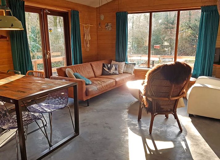 Gemuetliches Wohnzimmer im Cottage in Otterlo an der Veluwe, Ferienhaus in Gelderland mit Blick auf den Wald.