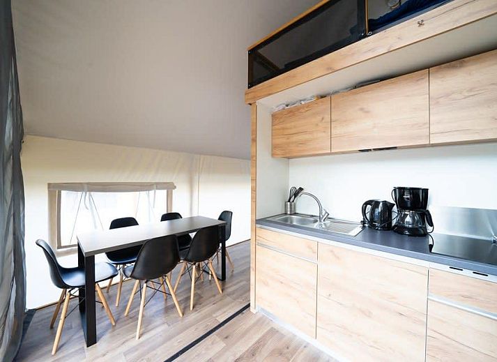 Stilvolle Einrichtung des Glampingtent 6 in Otterlo, Veluwe mit moderner Kueche und Essbereich fuer ein luxurioeses Glamping-Erlebnis.
