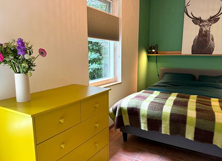 Ontspan in de groene tuin van Vakantiehuis in Otterlo, Veluwe, Gelderland, met comfortabele zitruimte en parasol voor een rustgevende ervaring.