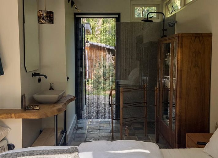 Gemuetliche Essecke im Ferienhaus in Otterlo, Veluwe, Gelderland, mit rustikalem Tisch und warmer Atmosphaere fuer einen entspannten Aufenthalt.