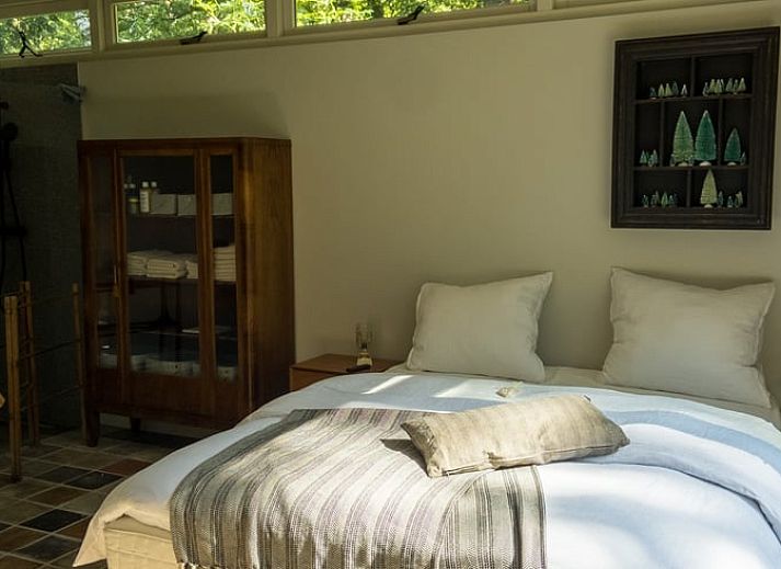 Gemuetliche Essecke im Ferienhaus in Otterlo, Veluwe, Gelderland, mit rustikalem Tisch und warmer Atmosphaere fuer einen entspannten Aufenthalt.