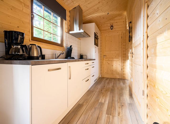 Gezellige woonkamer in Vakantiehuis Boekhorst 5, Otterlo, Veluwe met houten interieur en comfortabele zitruimte.