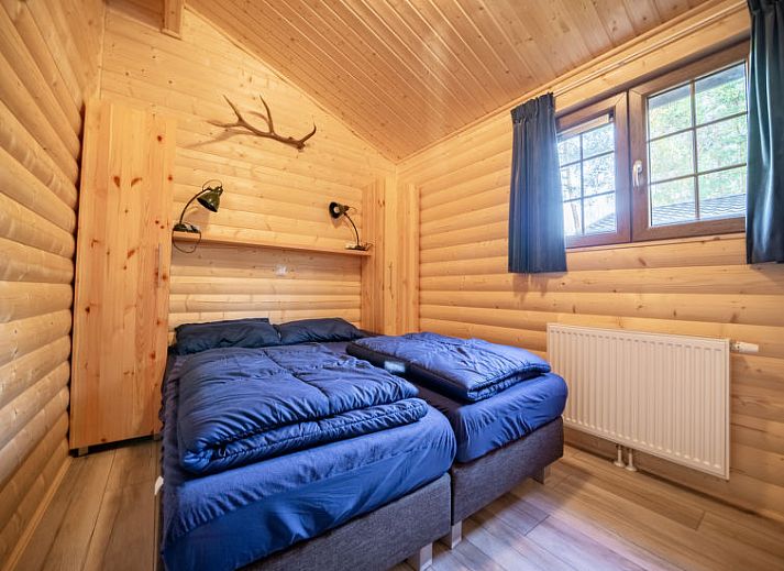 Gezellige woonkamer in Vakantiehuis Boekhorst 5, Otterlo, Veluwe met houten interieur en comfortabele zitruimte.