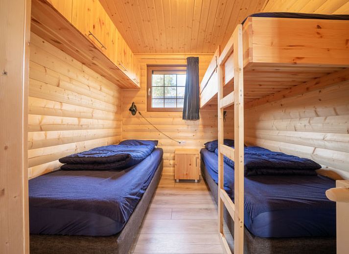 Eetgedeelte met houten tafel in Vakantiehuis Boekhorst 5, Otterlo, Veluwe, omringd door grote ramen en natuurlijk licht.