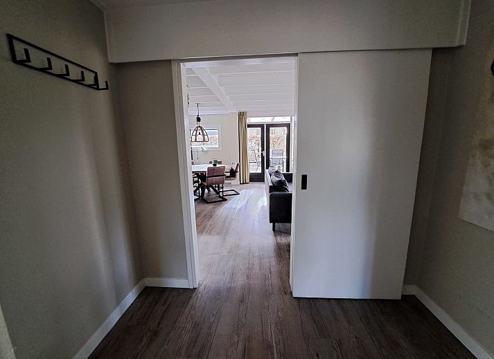 Essecke im adaptierten Bungalow het Edelhert, Ferienhaus in Epe, Veluwe, mit Holztisch und modernen Stuehlen.