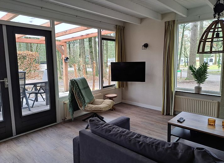 Essecke im adaptierten Bungalow het Edelhert, Ferienhaus in Epe, Veluwe, mit Holztisch und modernen Stuehlen.