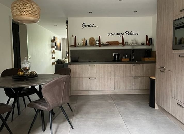 Cozy porch of Holiday Home in Epe in the Veluwe, Gelderland, with fireplace and views of the wooded landscape.