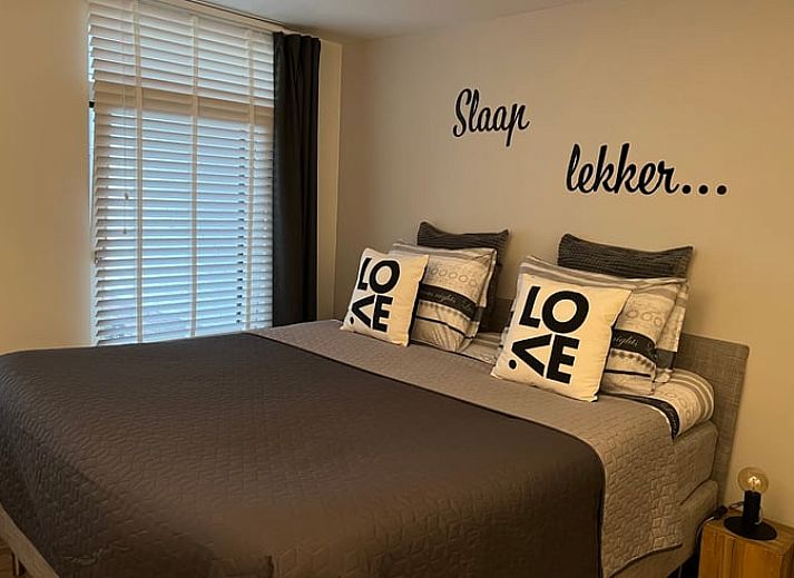 Cozy porch of Holiday Home in Epe in the Veluwe, Gelderland, with fireplace and views of the wooded landscape.