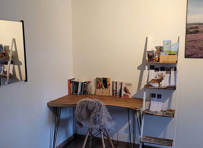 Cozy interior of Cottage in Epe, Veluwe with warm wood stove and drinks board, perfect for relaxation in Gelderland.