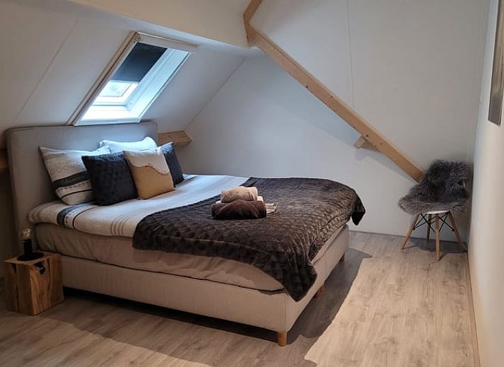 Cozy interior of Cottage in Epe, Veluwe with warm wood stove and drinks board, perfect for relaxation in Gelderland.