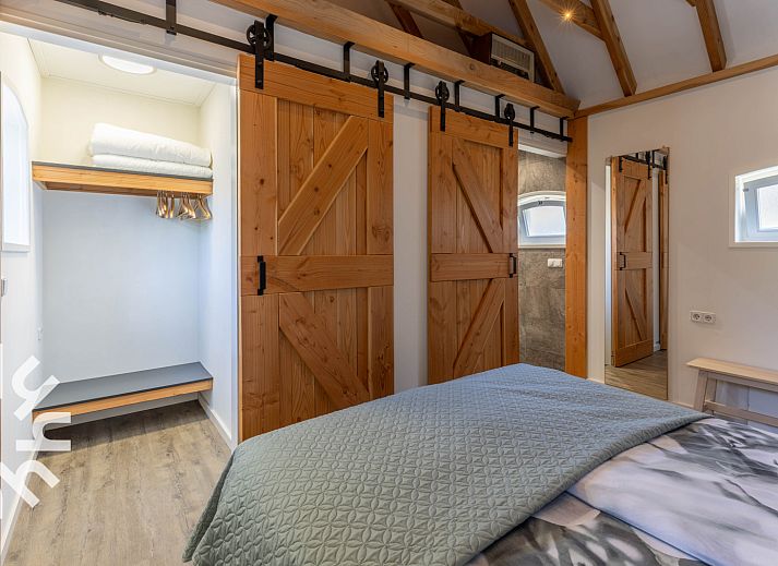 Sfeervolle slaapkamer in DG1439 vakantiehuis Epe, Veluwe met houten accenten.