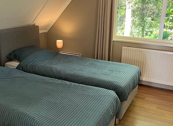 Gezellige woonkamer in Huisje in Epe, Veluwe, Gelderland met comfortabele banken en veel natuurlijk licht.