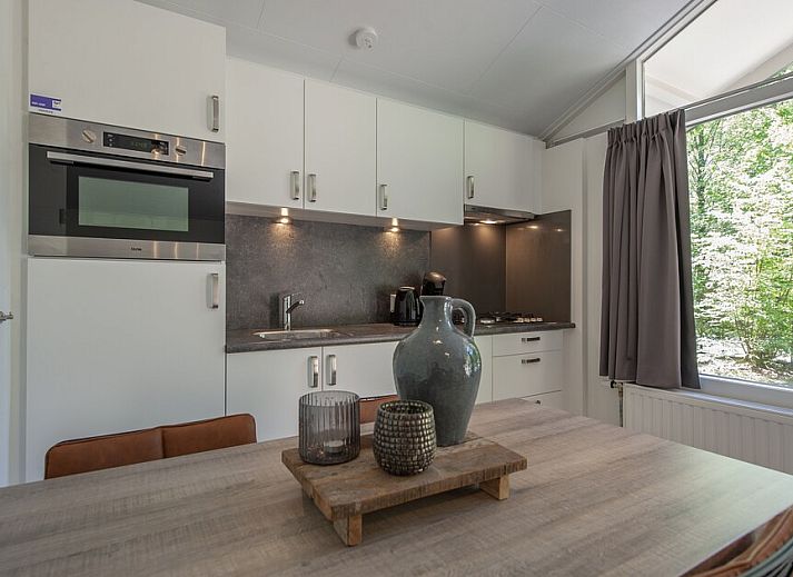Cozy living room of S4A Comfort bungalow in Epe, Veluwe, overlooking terrace and green surroundings.