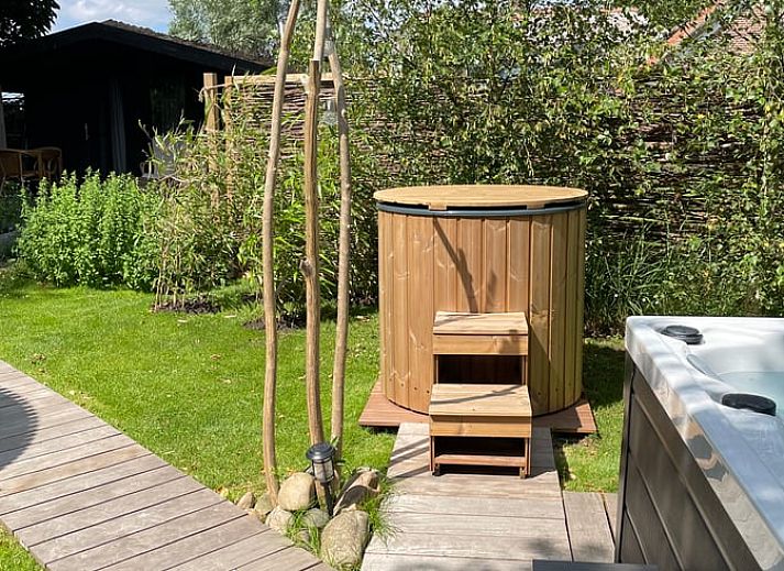 Entspannen Sie sich im Whirlpool des Ferienhauses in Scherpenzeel, Gelderland, mit Blick auf die gruene Veluwe-Landschaft.