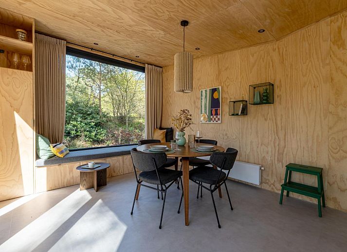 Gezellige binnenruimte van vakantiehuis Mos in Nunspeet, Veluwe met houten interieur en uitzicht op de natuur van Gelderland.