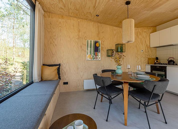 Gezellige binnenruimte van vakantiehuis Mos in Nunspeet, Veluwe met houten interieur en uitzicht op de natuur van Gelderland.