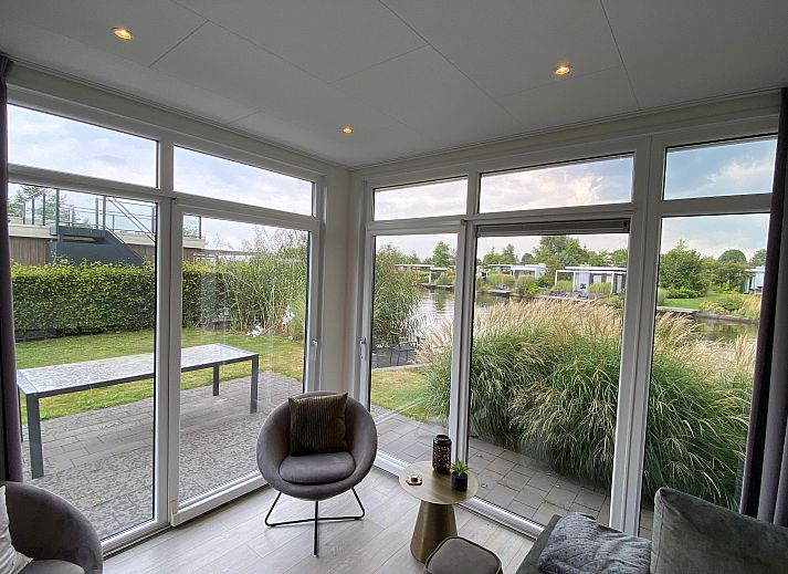 Lichte woonkamer van Chalet in Nunspeet, Veluwe, met uitzicht op natuur.