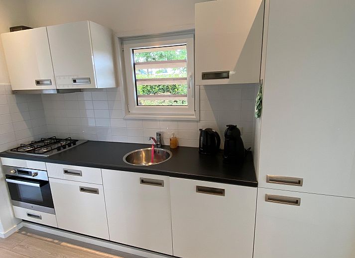 Lichte woonkamer van Chalet in Nunspeet, Veluwe, met uitzicht op natuur.