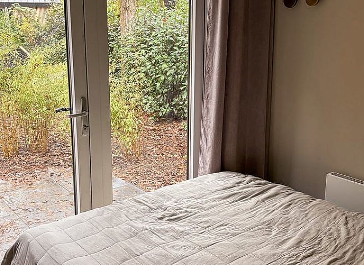 Entspannen Sie sich in einer Haengematte im Ferienhaus in Nunspeet, das in der Veluwe-Natur in Gelderland liegt und ueber eine charmante Holzterrasse verfuegt.