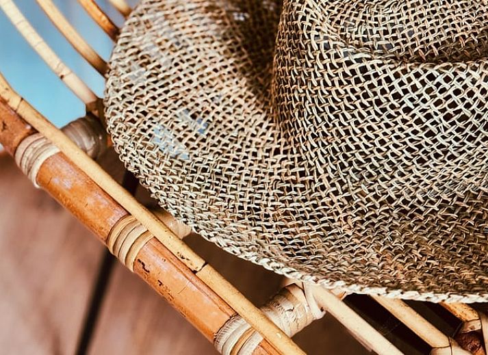 Stilvolle Ecke mit Rattanstuhl im Ferienhaus in Nunspeet, Veluwe, Gelderland, perfekt fuer Entspannung und Naturerlebnis.
