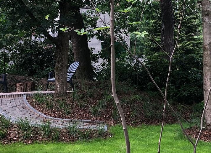 Gezellige zithoek met uitzicht op tuin bij Vakantiehuis in Nunspeet op de Veluwe.
