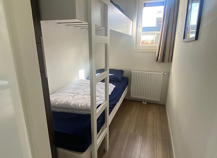 Moderne keuken in de Vrijstaande woning in Nunspeet, vakantiehuis op de Veluwe, Gelderland, met strakke witte kasten en houten vloer.