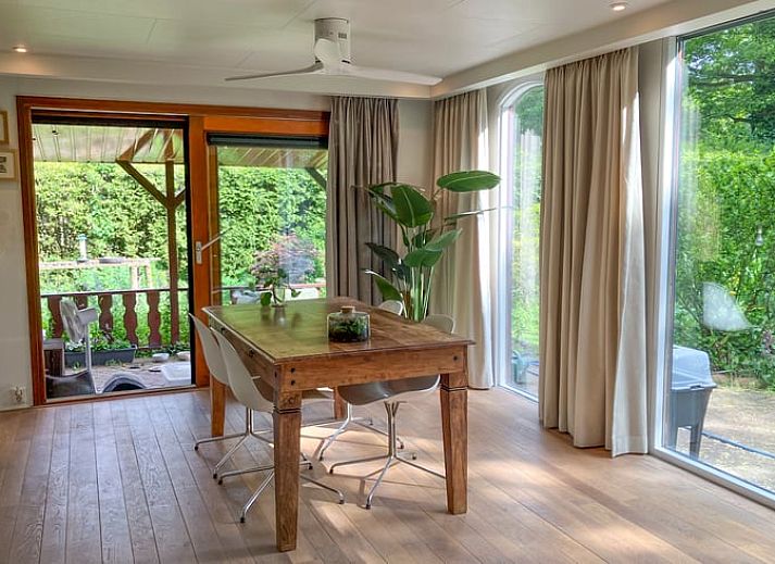 Cozy living room in Cottage in Lunteren, Veluwe, with wooden walls and comfortable sofas.