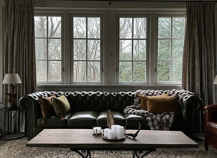 Gezellig vakantiehuis Huisje in Lunteren met rieten dak in de Veluwe, Gelderland omringd door groene natuur.