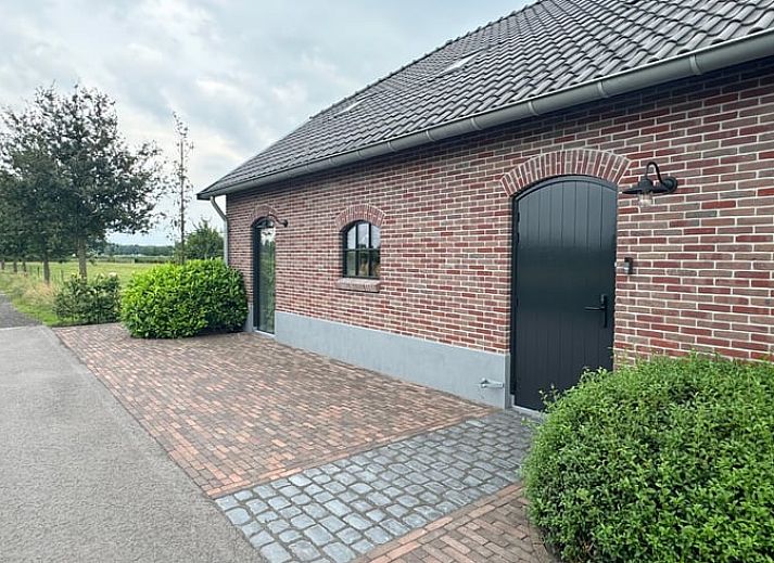 Ferienhaus in Lunteren in der Veluwe, Gelderland, umgeben von einer bunten Blumenwiese und gruener Natur.