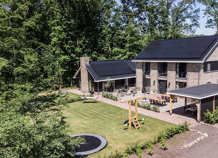 Geraeumiges Wohnzimmer in einem Ferienhaus in Oldebroek, Veluwe, mit modernen Moebeln und viel Licht.