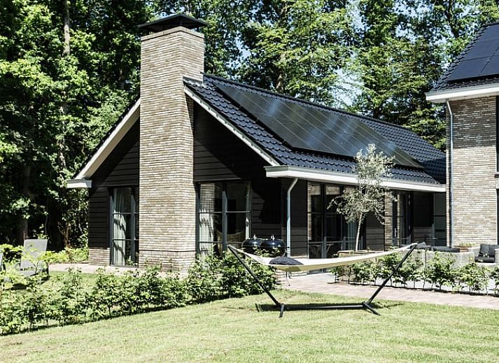 Geraeumiges Wohnzimmer in einem Ferienhaus in Oldebroek, Veluwe, mit modernen Moebeln und viel Licht.