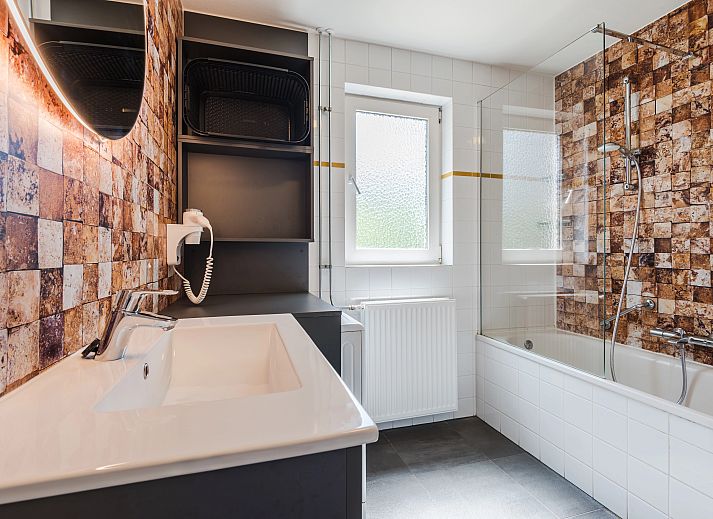 Cozy living room in Landgoed 't Loo 4-person bungalow 4L, Oldebroek, Veluwe with modern decor and garden views.