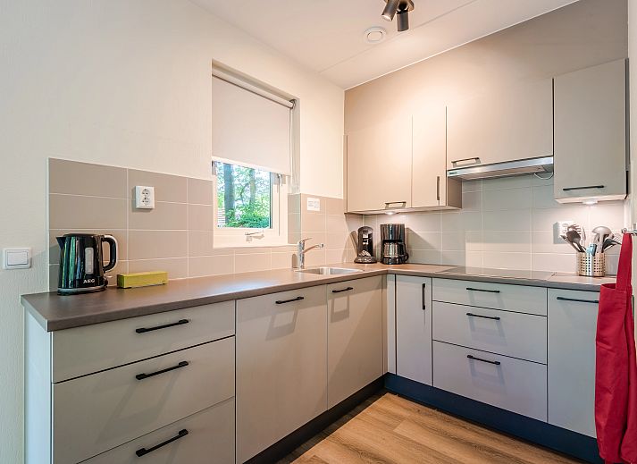 Buitenzijde van Landgoed 't Loo 6-persoons kinderbungalow 6CK, Oldebroek, Veluwe, omringd door herfstbladeren.