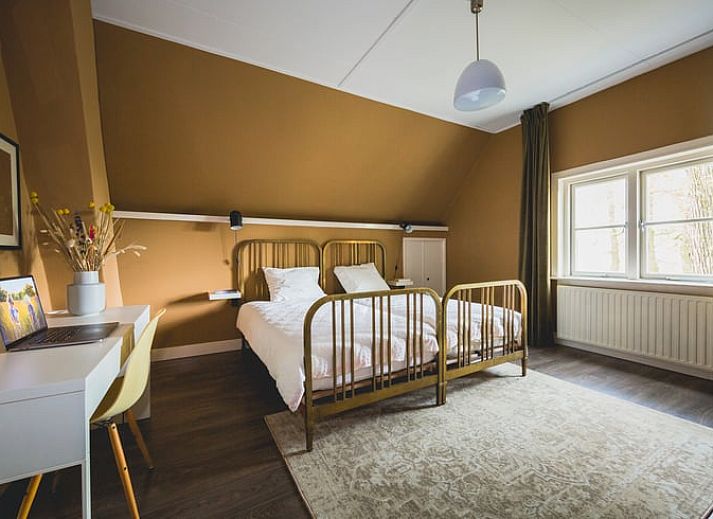 Huisje in Uddel, vakantiehuis in Veluwe, omringd door hoge bomen en een groene tuin, Gelderland.