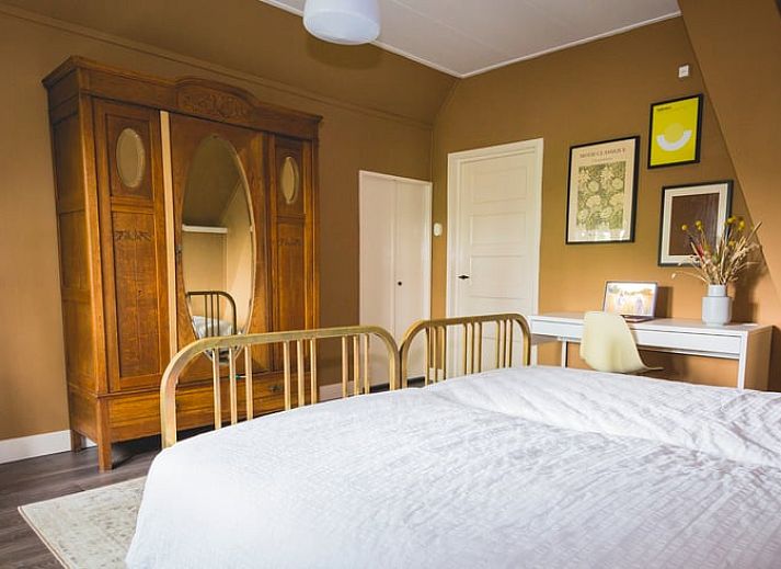 Huisje in Uddel, vakantiehuis in Veluwe, omringd door hoge bomen en een groene tuin, Gelderland.