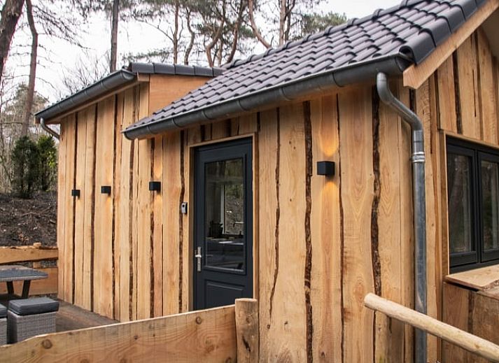 Vakantiehuisje in Uddel, Veluwe, met houten gevels en natuurlijke omgeving voor ultiem comfort.